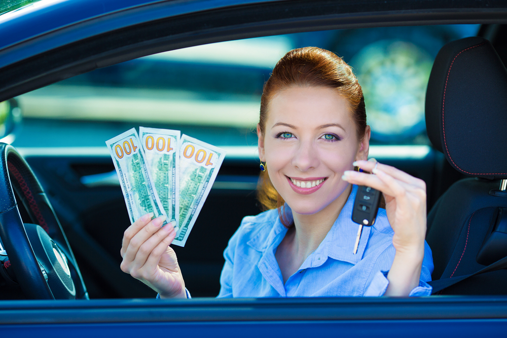 A woman holding money and car keys.